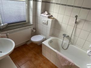 a bathroom with a toilet and a tub and a sink at Ferienwohnungen Medikus in Luftkurort Lückendorf