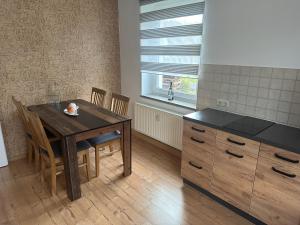 a kitchen with a wooden table and a table and chairs at Ferienwohnungen Medikus in Luftkurort Lückendorf +7 photos