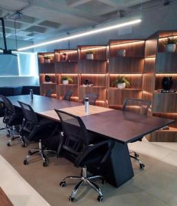 a conference room with a large wooden table and chairs at Stúdio, piscina, bicicleta, churrasqueira, restaurante, espaço gourmet, ar central in Maceió +45 photos