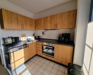 a small kitchen with wooden cabinets and appliances at Ferienwohnung Seeigel in Prerow