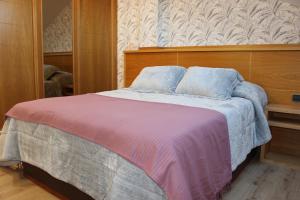 a bedroom with a large bed with a wooden headboard at La Parada del Camino in Negreira