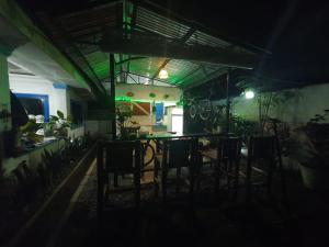 um quarto escuro com uma mesa e cadeiras à noite em Jah’s Anemone Dive Guesthouse em Moalboal