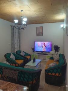 a living room with two couches and a flat screen tv at Village des Aviateurs 