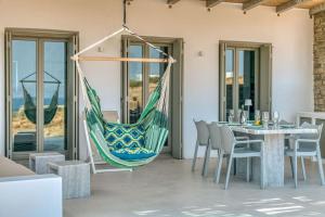 hamak wiszący na patio ze stołem i krzesłami w obiekcie Villa Ena - Beach getaway w mieście Logaras