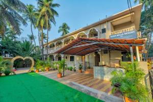 an external view of a hotel with a wooden deck and a building at Rosa Bella Resort-TBV in Calangute