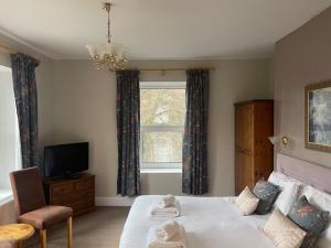 a bedroom with a bed and a tv and a window at The Westminster Hotel in Buxton