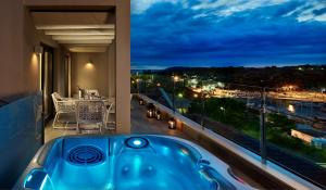 a bath tub in a room with a balcony with a view at Park Plaza Histria Pula in Pula