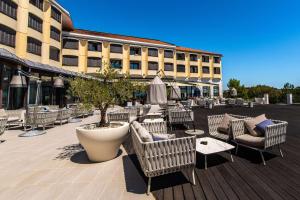 a patio with chairs and tables and a building at Park Plaza Histria Pula in Pula