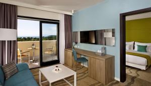 ein Hotelzimmer mit einem Bett, einem Schreibtisch und einem Zimmer in der Unterkunft Park Plaza Histria Pula in Pula