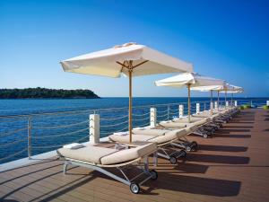 a row of lounge chairs and umbrellas on a boat at Park Plaza Histria Pula in Pula