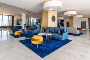a lobby with a blue couch and chairs and tables at Park Plaza Histria Pula in Pula