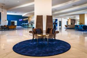 a lobby with a table and chairs on a rug at Park Plaza Histria Pula in Pula
