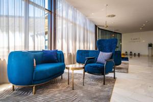 a lobby with two blue chairs and a table at Park Plaza Histria Pula in Pula