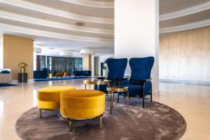 a lobby with blue chairs and a table at Park Plaza Histria Pula in Pula