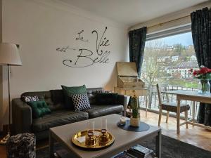 sala de estar con sofá y mesa en Au Pied Du Château en Bouillon