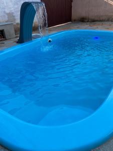 uma piscina azul com uma fonte de água em Casa conforto em Pirenópolis