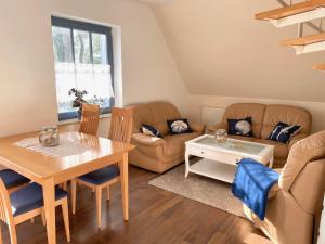 uma sala de estar com uma mesa e um sofá em Ferienwohnung Seeigel em Prerow