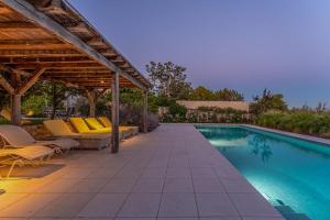 a swimming pool with chairs and a pergola at Charlotta in Radovani