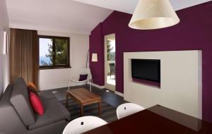 a purple living room with a couch and a tv at Park Plaza Verudela Pula in Pula