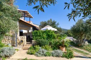 a house with a garden in front of it at Amazing house, 20 m from the beach, 80 m2 in Martinšćica