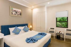 a bedroom with a large bed with blue pillows at Cat Ba Wonder Hotel in Cat Ba