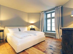 Un dormitorio con una gran cama blanca y una ventana en Großer Wal von Appartements & Mehr, en Munkmarsch