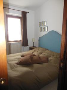 カステル・ディ・サングロにあるVilla Villacolle d'Eliaのベッドルーム1室(青いヘッドボード付きのベッド1台、窓付)