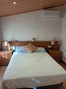 1 cama grande en un dormitorio con 2 lámparas en EVA & TRAVEL - CAL MARCEL - Habitacion, en Prades