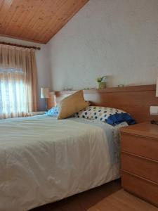 a bedroom with a white bed with a wooden headboard at EVA & TRAVEL - CAL MARCEL - Habitacion in Prades