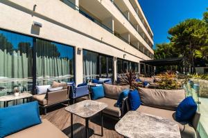 eine Terrasse mit Sofas und Tischen auf einem Gebäude in der Unterkunft Park Plaza Arena Pula in Pula