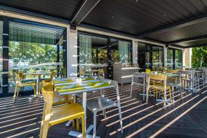 a restaurant with tables and chairs on a deck at Park Plaza Arena Pula in Pula