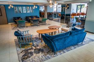 a restaurant with blue couches and tables and chairs at Park Plaza Arena Pula in Pula
