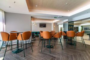 a bar with chairs and tables in a room at Park Plaza Arena Pula in Pula