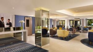 two people standing at a desk in a hotel lobby at Park Plaza Arena Pula in Pula