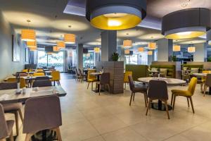 a restaurant with tables and chairs and lights at Park Plaza Arena Pula in Pula