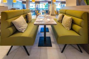 a dining room with two benches and a table at Park Plaza Arena Pula in Pula
