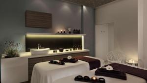 a bathroom with two beds and a sink and a tub at Park Plaza Arena Pula in Pula