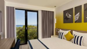 a hotel room with a bed and a large window at Park Plaza Arena Pula in Pula