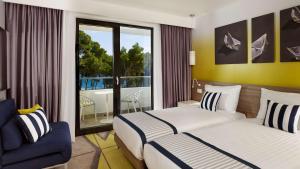 a hotel room with two beds and a balcony at Park Plaza Arena Pula in Pula