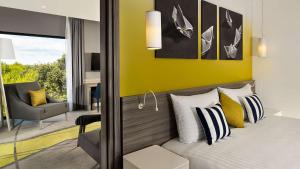 a bedroom with a bed and a yellow wall at Park Plaza Arena Pula in Pula