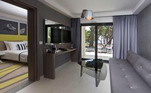 a bedroom with a bed and a tv and a couch at Park Plaza Arena Pula in Pula