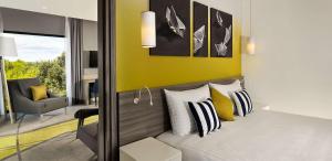 a bedroom with a bed with a yellow wall at Park Plaza Arena Pula in Pula
