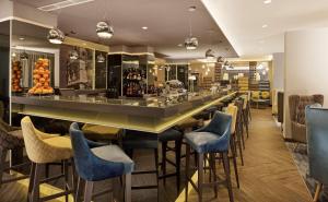 a bar in a restaurant with blue bar stools at Park Plaza Arena Pula in Pula