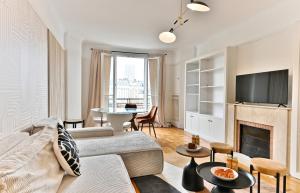 Una sala de estar con un sofá y una chimenea. en Luxurious Flat next Paris - Neuilly, en Neuilly-sur-Seine