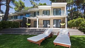 a house with two lounge chairs in front of it at Park Plaza Arena Pula in Pula