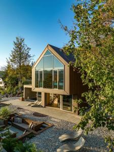 a small house with glass windows on a yard at Villa Luiv Chalet in Mrkopalj
