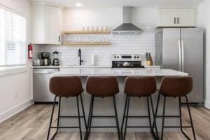una cocina con encimera con 3 taburetes en Ocean Lofts in the Vibe #5 - 5 min walk to beach, en Virginia Beach