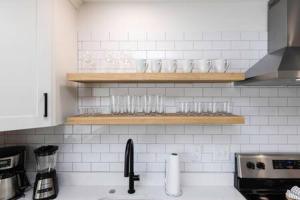 una encimera de cocina con fregadero y vasos en un estante en Ocean Lofts in the Vibe #5 - 5 min walk to beach, en Virginia Beach