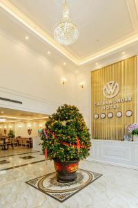 a lobby with a large christmas tree in a pot at Cat Ba Wonder Hotel in Cat Ba