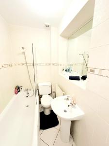 biała łazienka z toaletą i umywalką w obiekcie Cozy Studio in Angel (Islington) w Londynie